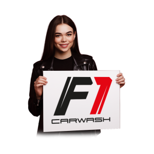 Žena držící ceduli s logem "F1 Carwash".