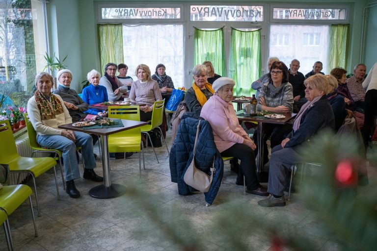 Skupina seniorů sedí v kavárně u stolu