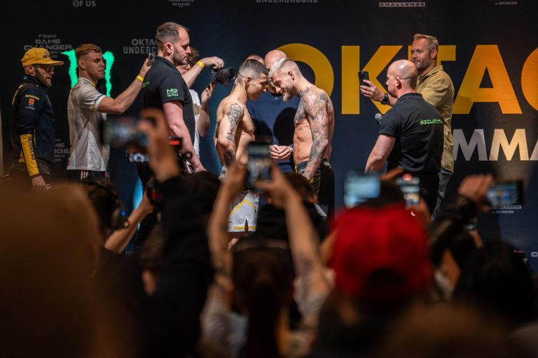 Dva bojovníci na vážení před zápasem, obklopeni diváky