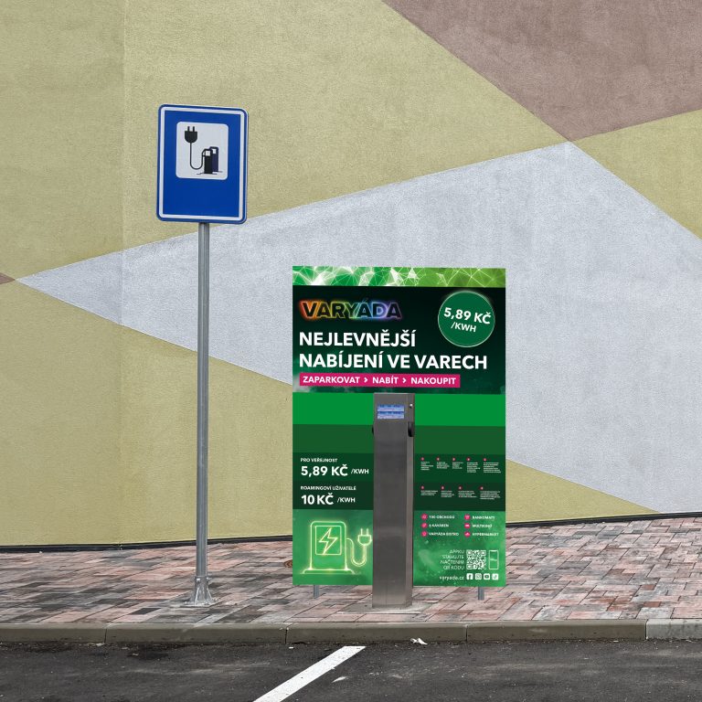 Nabíjecí stanice se stojanem a informační tabulí na chodníku