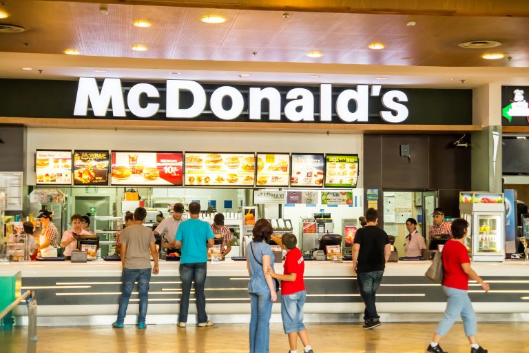 Lidé stojí frontu u pultu rychlého občerstvení McDonald's