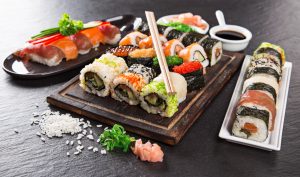 Výběr různorodého sushi na dřevěném prkénku se sójovou omáčkou
