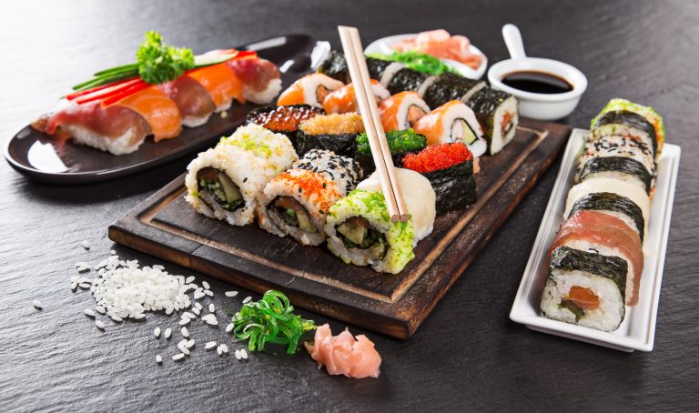 Výběr různorodého sushi na dřevěném prkénku se sójovou omáčkou