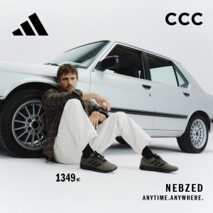 Muž sedící u bílého auta v botách adidas Nebzed